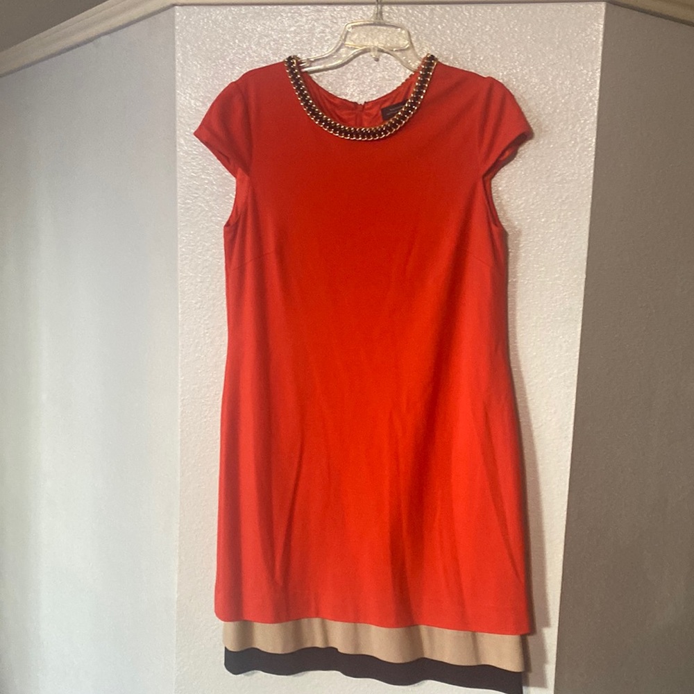 Orange sleeve dress with tan and black bottom. Gold chain black ribbon